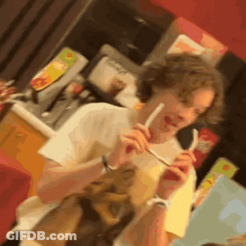 A Blurred Image Of A Person Eating A Sandwich With A Straw GIF