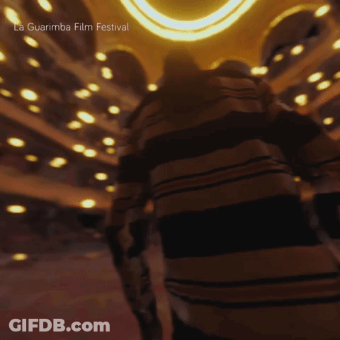 A Blurred Image Of A Person In A Dark Room With The Words La Guarimba Film Festival Visible GIF