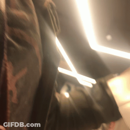A Blurred Image Of A Person 'S Back With A Light Shining On It GIF