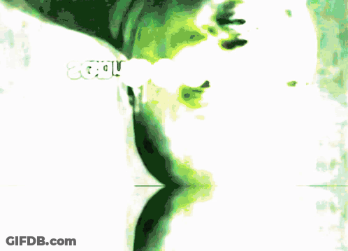 A Blurred Image Of A Person 'S Face With A Green Background GIF