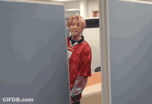 A Blurred Image Of A Person Standing Between Two Blue Dividers GIF