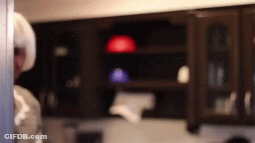 A Blurred Image Of A Person Standing In A Kitchen . GIF