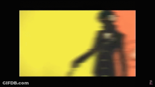 A Blurred Image Of A Person Standing In Front Of A Yellow And Red Background . GIF