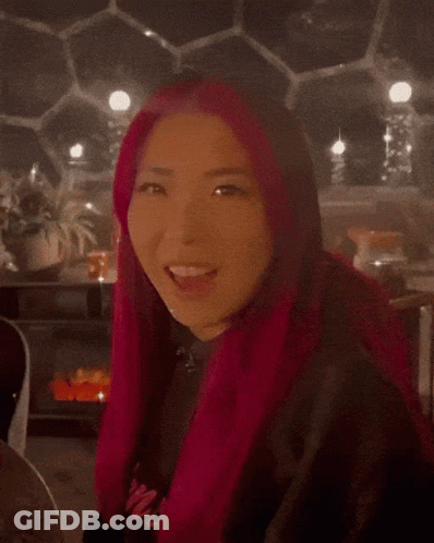 A Blurred Image Of A Person Wearing A Red Coat And A Black Shirt GIF
