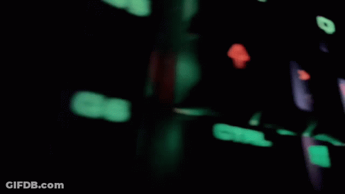 A Blurred Image Of A Room With A Brick Wall And A Computer Monitor GIF