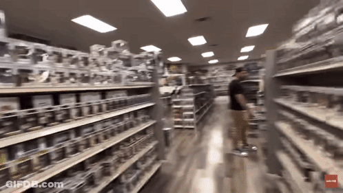 A Blurred Image Of A Store Aisle With A Red Arrow Pointing To The Bottom Left GIF
