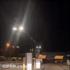 A Blurred Image Of A Street At Night With A Sign That Says ' Emergency Exit ' On It GIF
