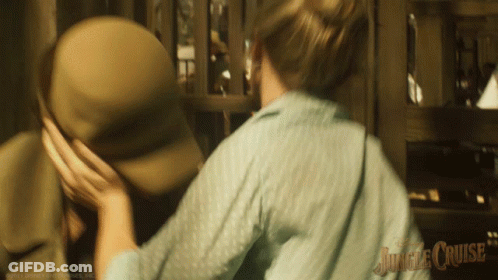 A Blurred Image Of A Woman Holding A Man 'S Hat With Jungle Cruise Written On The Bottom Right GIF