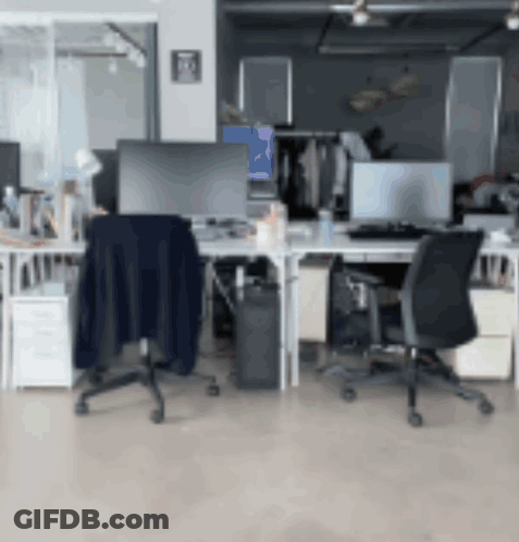 A Blurred Image Of An Office With A Blue Item On The Wall GIF
