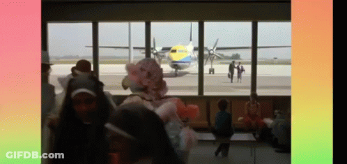 A Blurred Image Of People Looking Out A Window At An Airplane GIF
