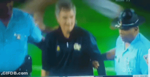 A Blurred Image Of Two Police Officers And A Man On A Green Screen With The Time 0:02 GIF