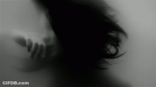 A Blurry Black And White Photo Of A Woman 'S Face Behind A Glass Wall . GIF