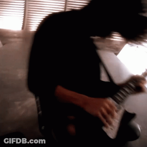 A Blurry Image Of A Person Playing An Electric Guitar GIF