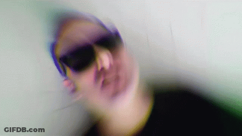 A Blurry Image Of A Person Wearing Sunglasses GIF