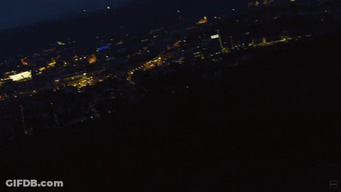 A Blurry Photo Of A City At Night With A Blue Sky GIF