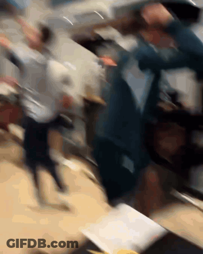 A Blurry Photo Of A Group Of People Dancing In A Room GIF