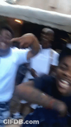 A Blurry Photo Of A Group Of People Dancing In A Room GIF