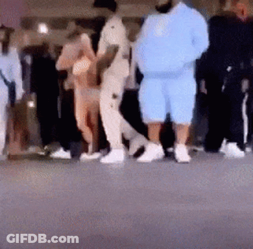 A Blurry Photo Of A Group Of People Standing On A Street . GIF