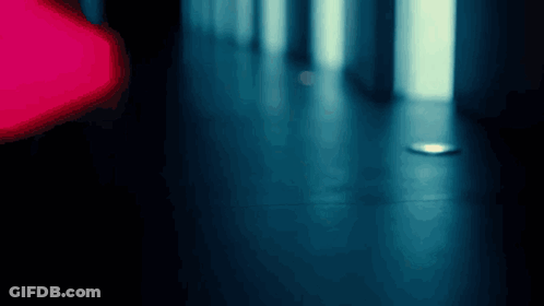 A Blurry Photo Of A Hallway With A Red Light In The Background GIF