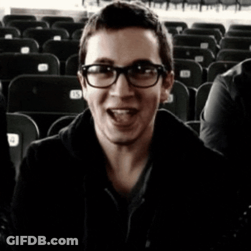 A Blurry Photo Of A Man Wearing Glasses And A Black Coat GIF