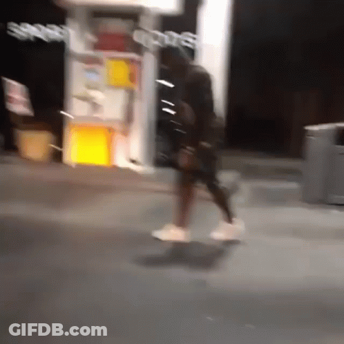 A Blurry Photo Of A Person Walking In Front Of A Store That Says Sports GIF