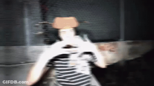 A Blurry Photo Of A Person Wearing A Cowboy Hat And A Striped Shirt GIF