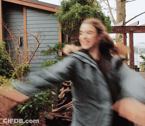 A Blurry Photo Of A Woman Dancing In Front Of A House GIF