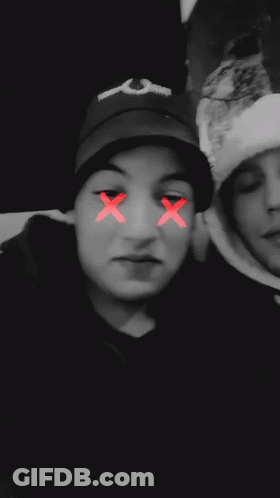 A Blurry Photo Of Two People With A Red Smiley Face On Their Face GIF