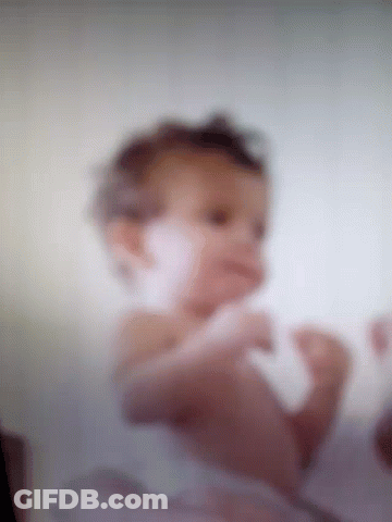 A Blurry Picture Of A Baby Laying On Its Stomach GIF
