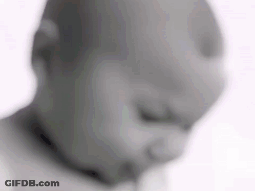 A Blurry Picture Of A Baby 'S Face With A Pacifier In His Mouth . GIF