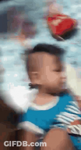 A Blurry Picture Of A Baby With A Blue Shirt On GIF