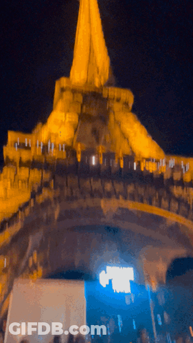 A Blurry Picture Of A Building At Night With A Blue Light Shining On It GIF