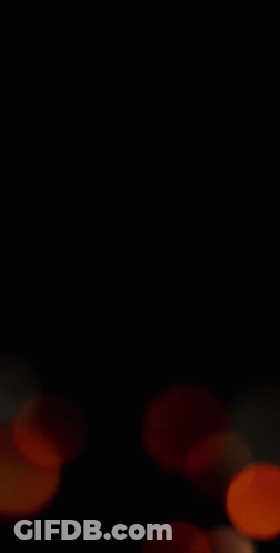 A Blurry Picture Of A Bunch Of Orange Circles On A Black Background . GIF