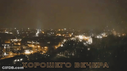 A Blurry Picture Of A City At Night With The Words Хорошего Вечера In Gold Letters GIF