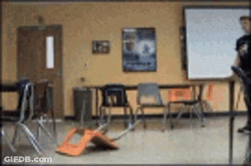 A Blurry Picture Of A Classroom With Chairs And Tables GIF