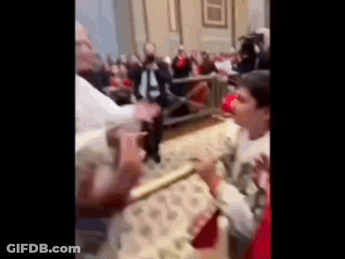 A Blurry Picture Of A Crowd Of People Standing In A Church . GIF