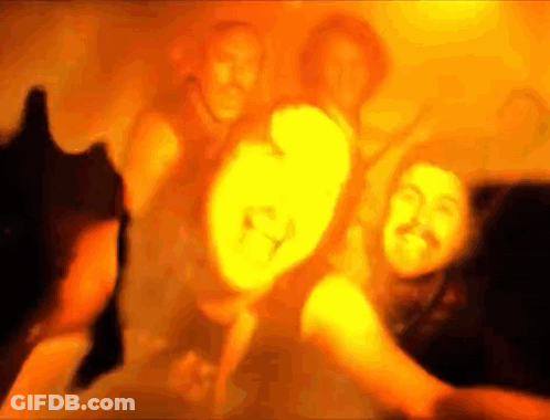 A Blurry Picture Of A Group Of People Dancing In A Dark Room . GIF