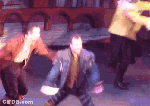 A Blurry Picture Of A Group Of People Dancing In Front Of A Building GIF