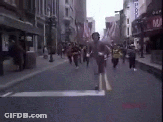 A Blurry Picture Of A Group Of People Running Down A Street . GIF