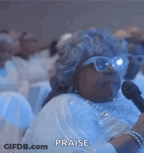 A Blurry Picture Of A Group Of People Sitting In A Room With The Words Praise Written On The Bottom . GIF