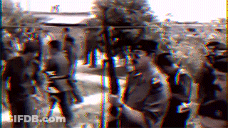 A Blurry Picture Of A Group Of People Standing Around GIF