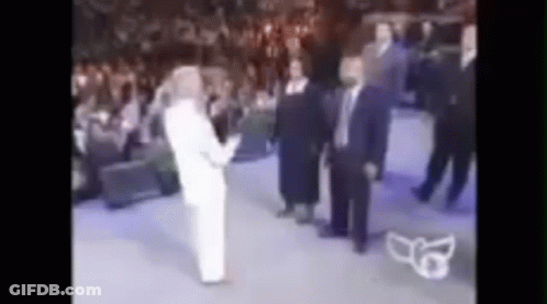 A Blurry Picture Of A Group Of People Standing In A Room . GIF
