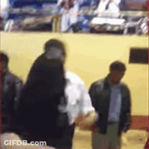 A Blurry Picture Of A Group Of People Standing In Front Of A Wall GIF