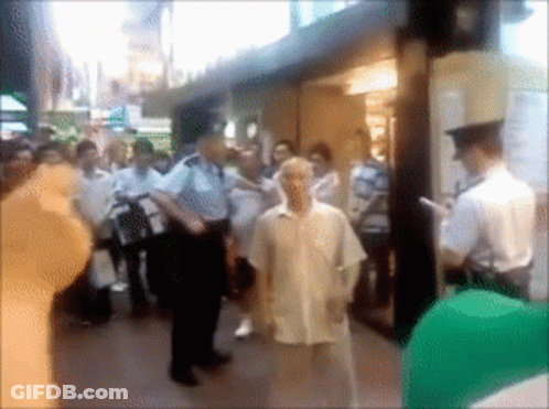 A Blurry Picture Of A Group Of People Standing Outside A Building GIF