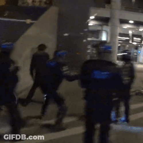 A Blurry Picture Of A Group Of Police Officers In Blue Uniforms GIF