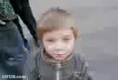 A Blurry Picture Of A Little Boy Holding A Person 'S Hand . GIF