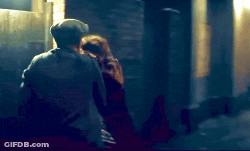 A Blurry Picture Of A Man And A Woman In A Dark Alleyway GIF