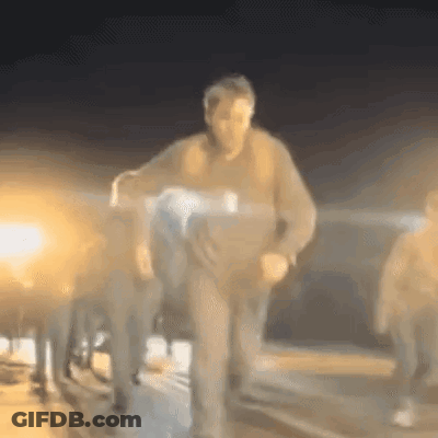A Blurry Picture Of A Man Carrying A Person In A Wheelchair At Night . GIF