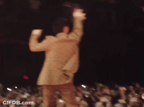 A Blurry Picture Of A Man Dancing On Stage In Front Of A Crowd . GIF