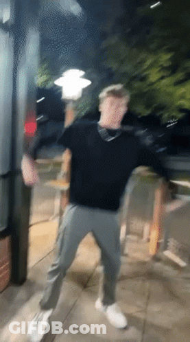 A Blurry Picture Of A Man Dancing On The Sidewalk GIF